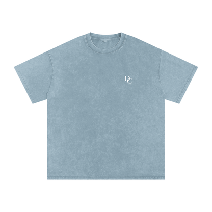 Don Chevere Asphalt Oversized Essential Tee, a washed blue 100% cotton t-shirt with a small white DC logo on the left chest.