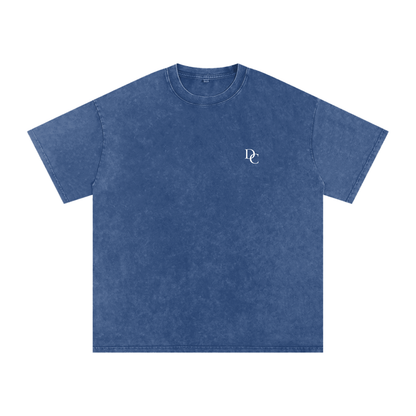 Don Chevere Asphalt Oversized Essential Tee, a washed blue 100% cotton t-shirt with a relaxed fit and subtle white DC logo on the chest.