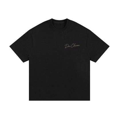 Don Chevere black 100% cotton oversized heavy tee with short sleeves and a round neck. Features a subtle gold logo on the left chest.