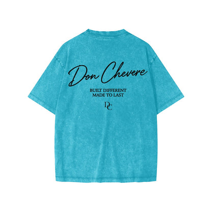 Don Chevere blue washed cotton short sleeve kids' tee with "BUILT DIFFERENT MADE TO LAST" graphic.