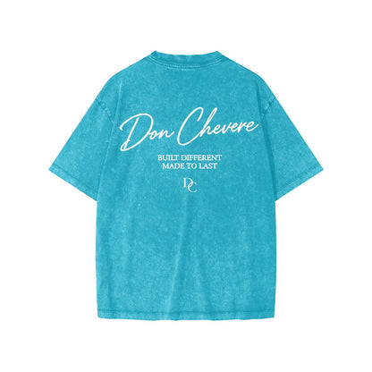 Don Chevere snow washed kids' tee in turquoise blue, 100% cotton with white text graphic on back.