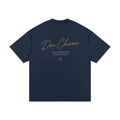 Don Chevere navy blue 100% cotton oversized heavy tee with gold text graphic on back.