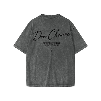 Don Chevere snow washed kids' tee in charcoal grey 100% cotton with short sleeves and a round neck. Features text print.